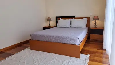 a bedroom with a bed with two night stands and two lamps at Hills and Atlantic Ocean retreat - Conceição House in Calheta