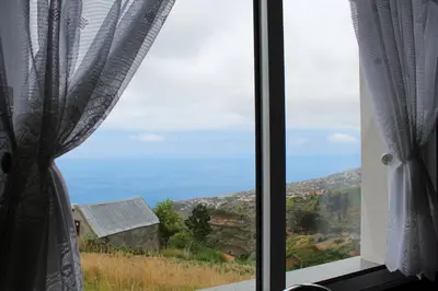 a view of the ocean from a window at Hills and Atlantic Ocean retreat - Conceição House in Calheta