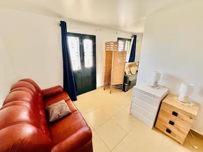 a living room with a leather couch and a table at Maria Cottage with Sea View in Estreito da Calheta