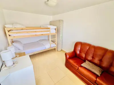 a living room with a couch and a bunk bed at Maria Cottage with Sea View in Estreito da Calheta