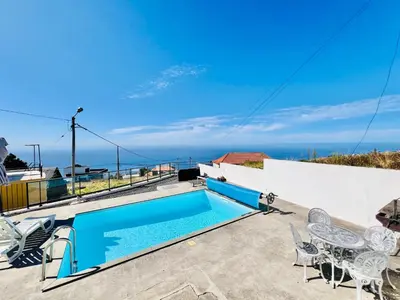 a swimming pool on the roof of a house at Maria Cottage with Sea View in Estreito da Calheta