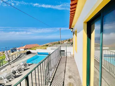 a balcony with a view of the ocean from a house at Maria Cottage with Sea View in Estreito da Calheta