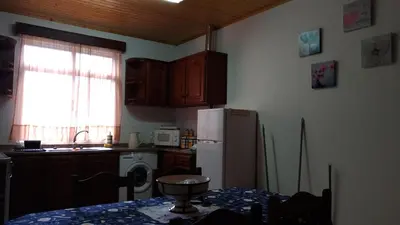 a kitchen with a refrigerator and a table with a bowl on it at Ape Esquerdo in São Vicente