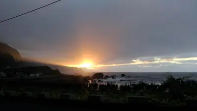a sunset over the ocean with the sun setting at Ape Esquerdo in São Vicente