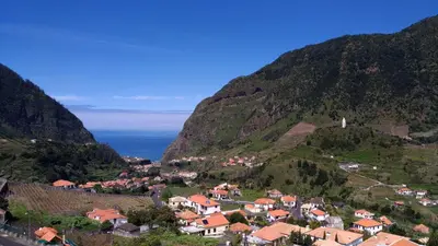 a village on a hill with the ocean in the background at Ape Esquerdo in São Vicente