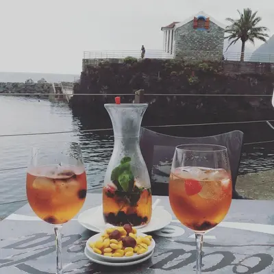 two glasses of drinks and a vase on a table at Ape Esquerdo in São Vicente
