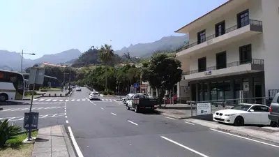 an empty street with cars parked on the side of a building at Ape Esquerdo in São Vicente