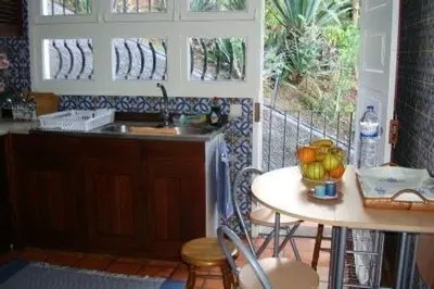 a kitchen with a table with a bowl of fruit on it at Apartamento Charmoso no Funchal, com grande Jardim e Vista Esplêndida in Funchal