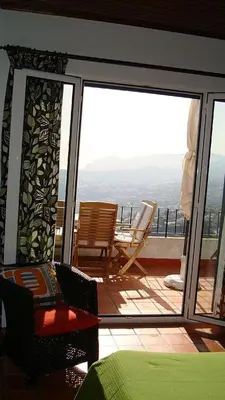 a room with a balcony with a table and chairs at Apartamento Charmoso no Funchal, com grande Jardim e Vista Esplêndida in Funchal