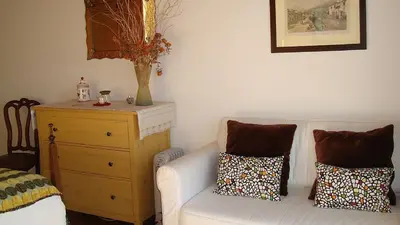 a living room with a white couch and a dresser at Apartamento Charmoso no Funchal, com grande Jardim e Vista Esplêndida in Funchal