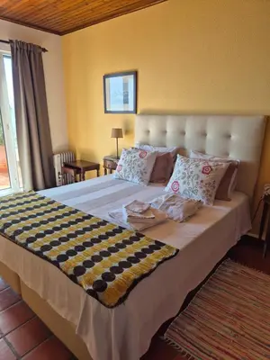 a bedroom with a large bed with pillows at Apartamento Charmoso no Funchal, com grande Jardim e Vista Esplêndida in Funchal