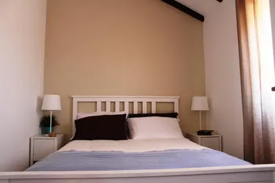 a bedroom with a large bed with two night stands at Trivial Pisão - Casa de Férias, para a sua Família in Raposeira