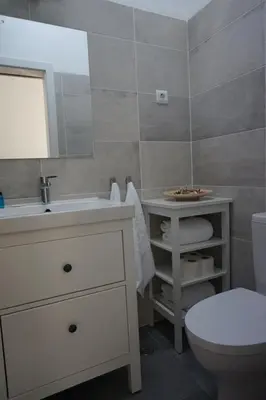 a bathroom with a sink and a toilet and a mirror at Trivial Pisão - Casa de Férias, para a sua Família in Raposeira