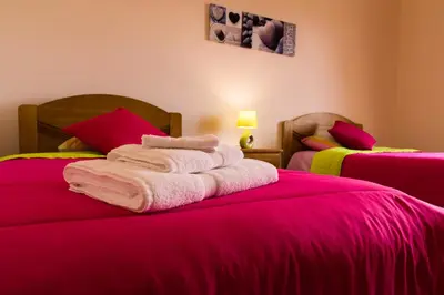 a bedroom with two beds with pink sheets at Casa Nunes in Santana