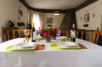 a table with plates and wine glasses and flowers on it at Casa Nunes in Santana