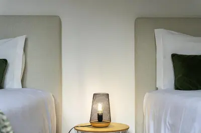 a lamp sitting on a table next to two beds at Gouveia Cottage in Seixal