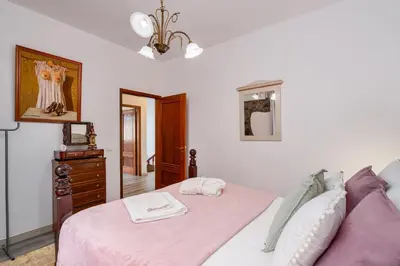 a bedroom with a pink bed and a dresser at Gouveia Cottage in Seixal