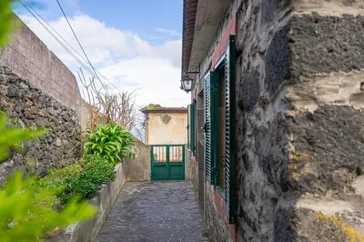 a narrow alley with a green door in a building at Gouveia Cottage in Seixal