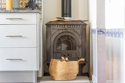 a basket sitting in front of a fireplace in a kitchen at Gouveia Cottage in Seixal