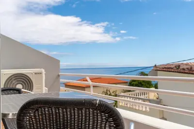 a balcony with a table and chairs and the ocean at TarmarPlace in Jardim do Mar