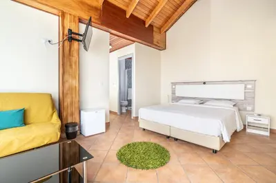 a bedroom with a bed and a couch at TarmarPlace in Jardim do Mar