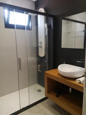 a bathroom with a glass shower and a sink at Green Apartment in Funchal