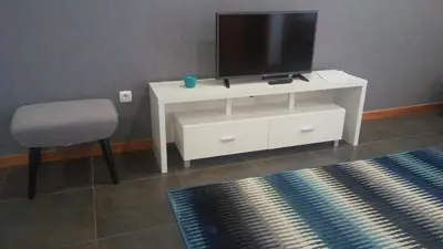 a white entertainment center with a tv and a chair at Five Design Rooftop by Storytellers in Funchal