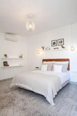a white bedroom with a bed with white sheets and pillows at Quinta B. in Funchal