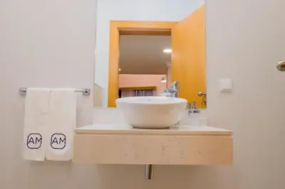 a bathroom with a white sink and a mirror at Apartments Madeira City Center in Funchal