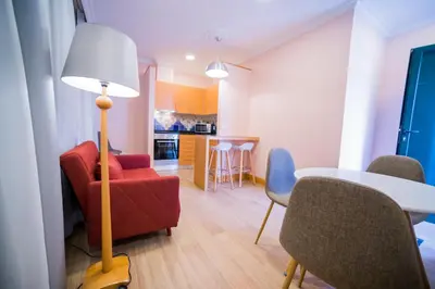 a living room with a red chair and a table at Apartments Madeira City Center in Funchal