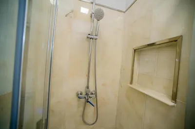 a shower with a glass door and a shower head at Apartments Madeira City Center in Funchal