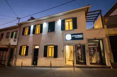a white building with black shutters on it at Apartments Madeira City Center in Funchal