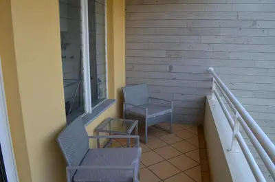 a balcony with two chairs and a table and a window at Enzo Apartament in Funchal