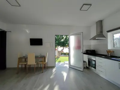 a kitchen and dining room with a table and a dining room at Madeira Blue House in Calheta