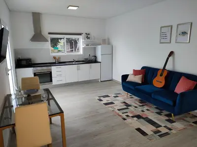 a living room with a blue couch and a guitar at Madeira Blue House in Calheta