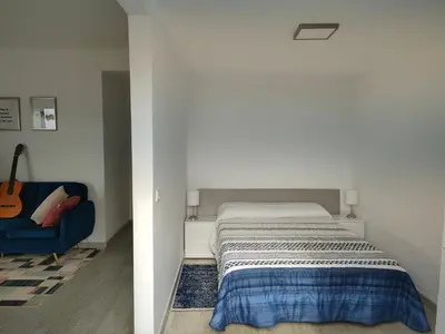 a bedroom with a bed and a blue chair at Madeira Blue House in Calheta