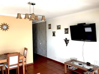 a living room with a flat screen tv on a wall at Apartamento Romantico in Caniço