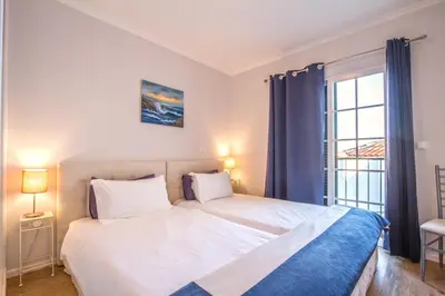 a bedroom with a large white bed and a window at Old Town House Madeira in Funchal