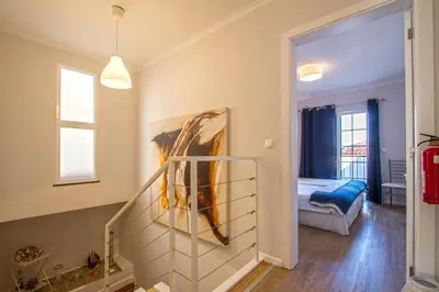 a room with a staircase and a bedroom with a bed at Old Town House Madeira in Funchal