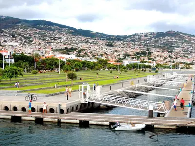 a bridge over a river with a boat in the water at Old Town House Madeira in Funchal