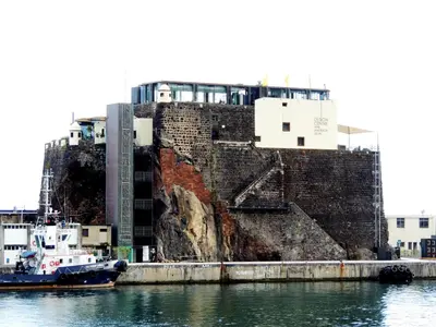a boat is docked in front of a building at Old Town House Madeira in Funchal