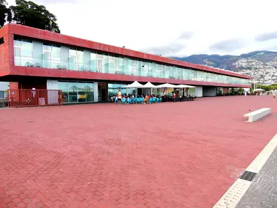 a red building with a red brick courtyard with a bench at Old Town House Madeira in Funchal