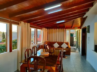 a living room with a table and a couch at Rochinha House in Funchal