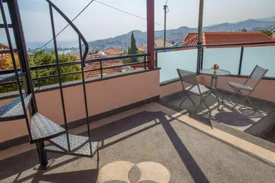 a balcony with a table and chairs and a view at Rochinha House in Funchal