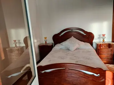 a bedroom with a wooden bed and a mirror at Rochinha House in Funchal
