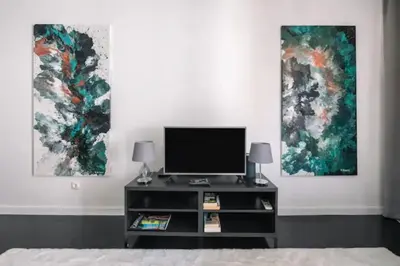 two paintings on a wall in a room at Artist Loft - Modern Stay in Historic Old Town in Funchal