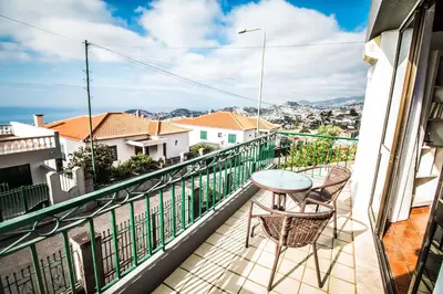 a balcony with a table and chairs on a building at Monte Vista Hermosa in Funchal