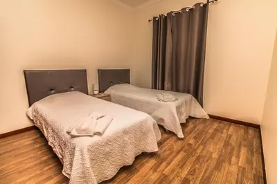 two beds in a room with wooden floors at Monte Vista Hermosa in Funchal