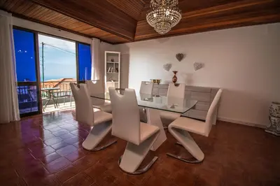 a dining room with a glass table and chairs at Monte Vista Hermosa in Funchal