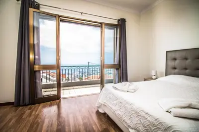 a bedroom with a bed and a large window at Monte Vista Hermosa in Funchal